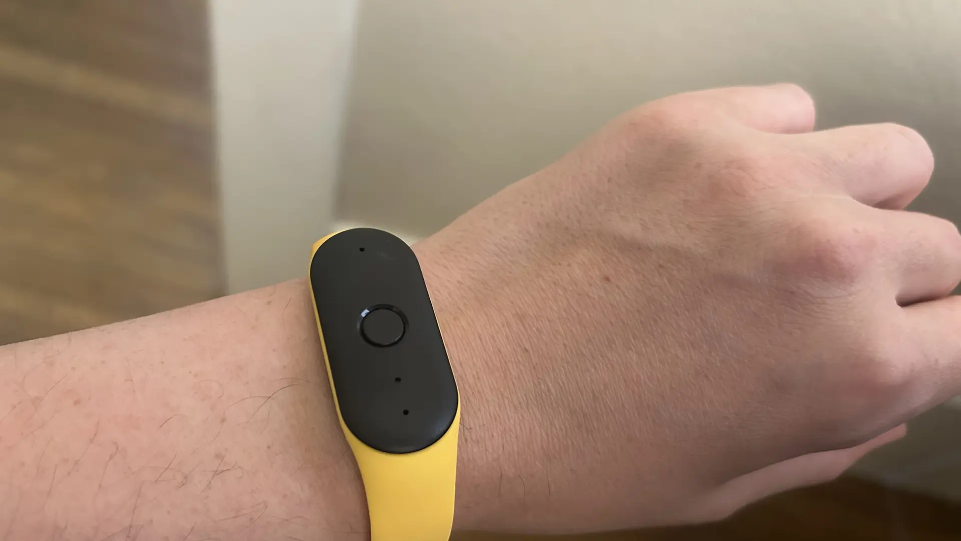 Amazon Bee AI wearable bracelet detail showing the green recording indicator and the button placement on the device
