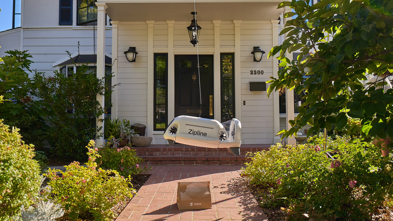 Zipline drone delivery dropping a package at a home porch
