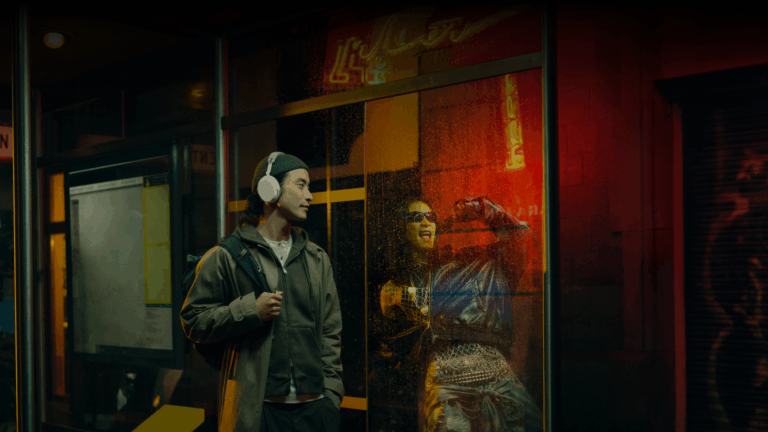 Sennheiser Momentum 5 Wireless headphones worn in white at a city bus stop