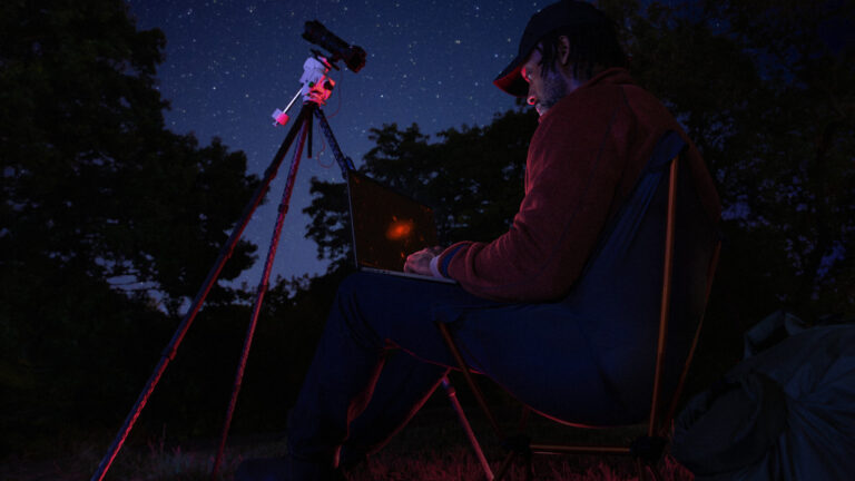 MacBook Pro used outdoors at night, the kind of pro work the OLED MacBook Pro targets
