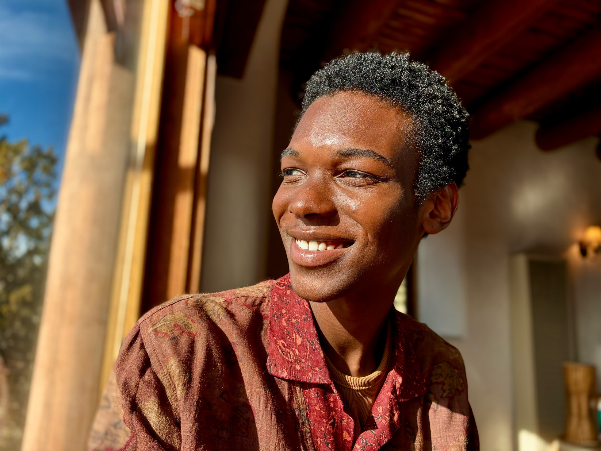 Sunlit portrait of a smiling man shot in Portrait mode on the iPhone 16e