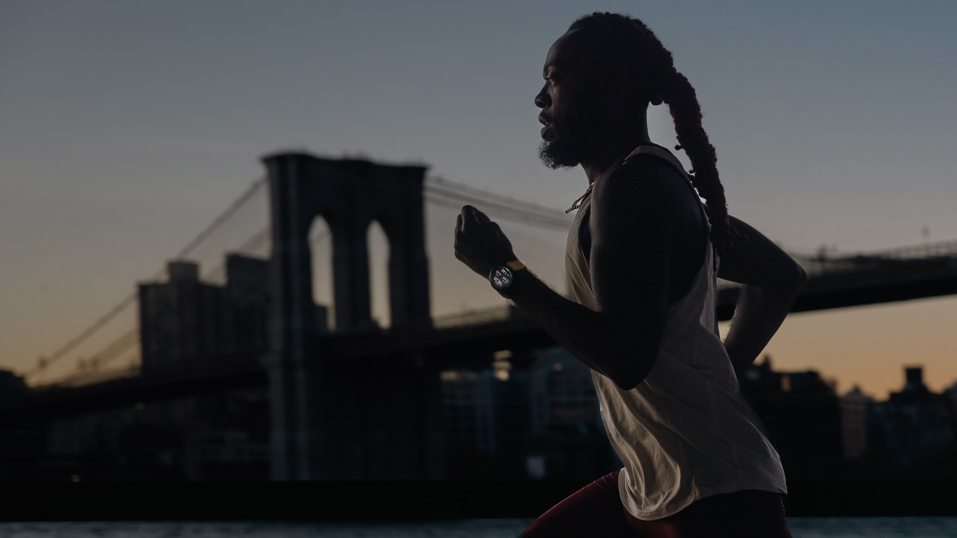 Runner using a Garmin watch during a long-distance training run at dusk
