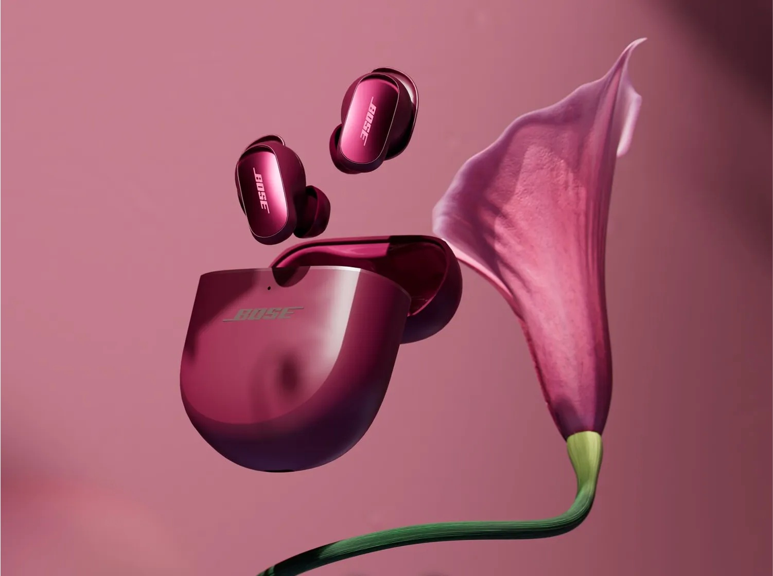 Bose QuietComfort Ultra Earbuds 2nd Gen and open charging case in Deep Plum beside a flower