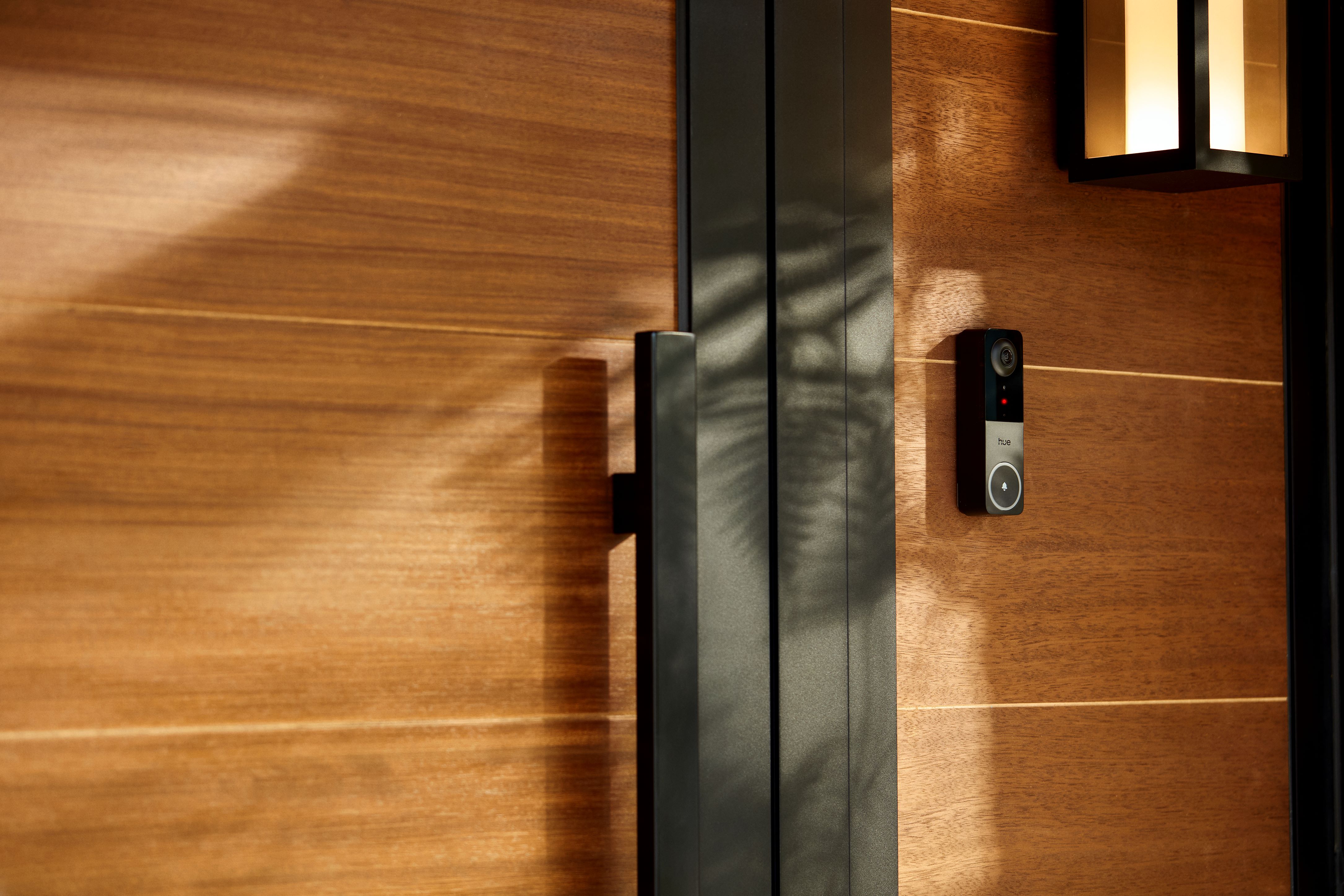 Philips Hue Secure video doorbell beside a front door, a Matter-era smart home security device