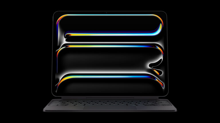 iPad Pro M5 attached to the black Magic Keyboard with an abstract wallpaper on the OLED display
