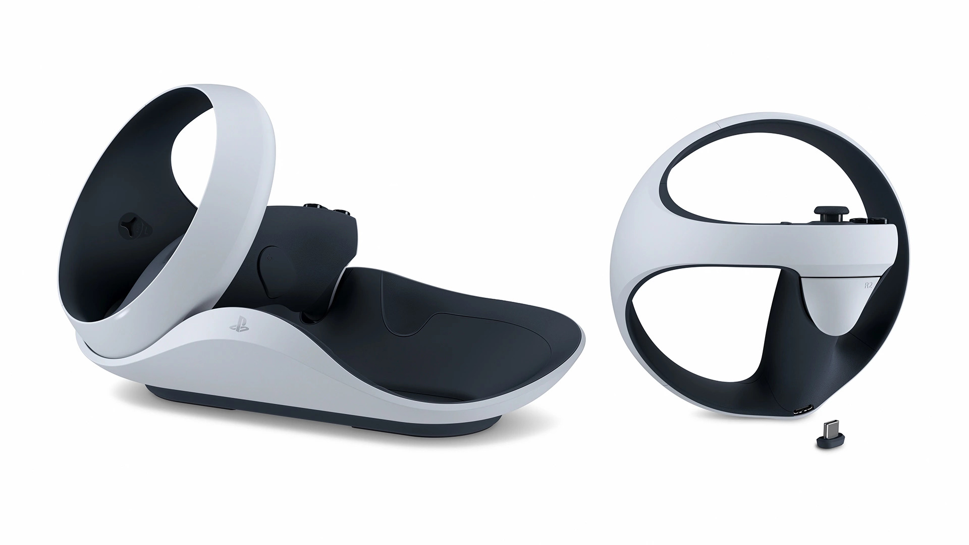 PS VR2 Sense controller resting in the white charging station next to a second controller and the small USB-C charging connector