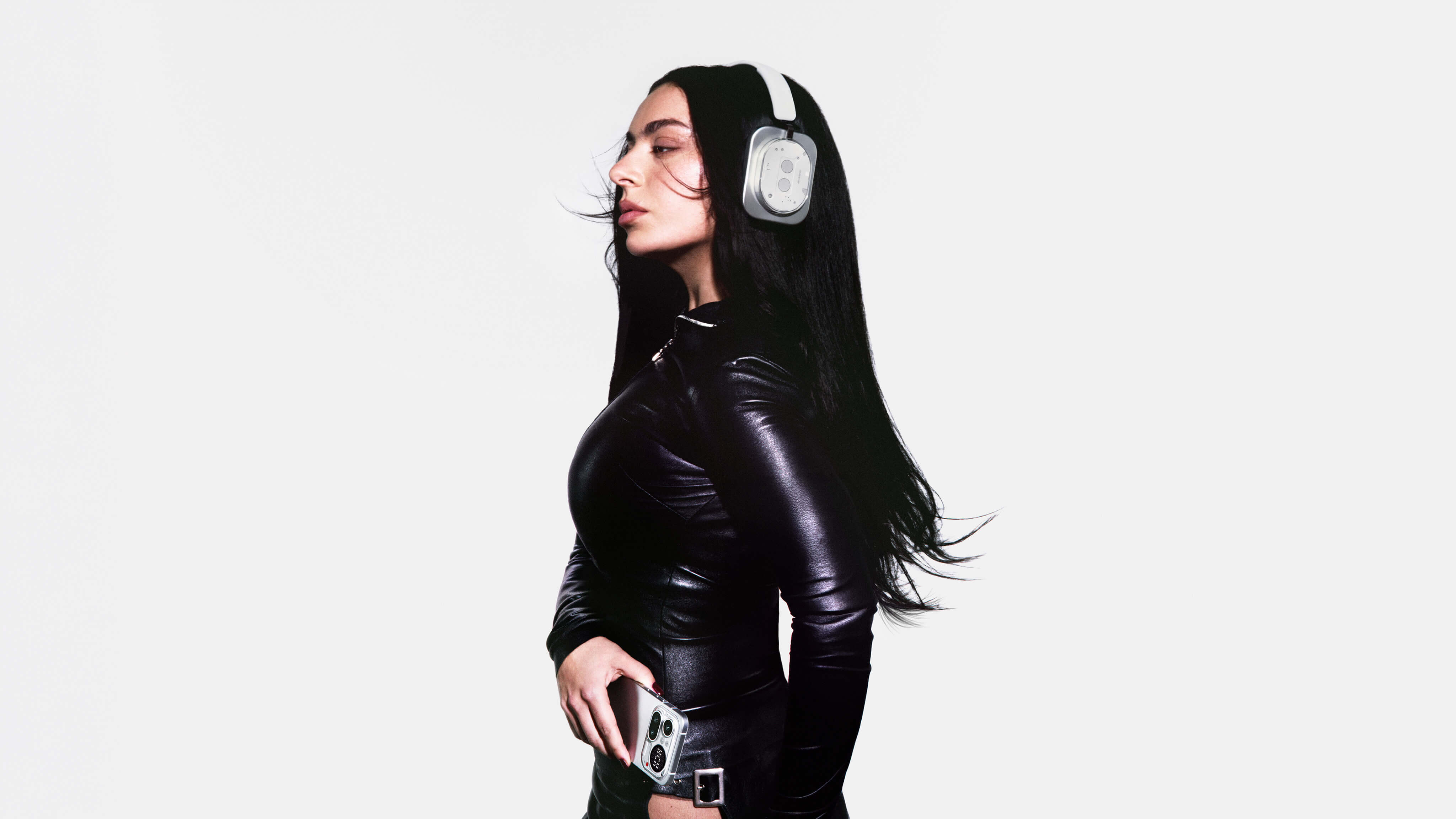 Listener wearing the white Nothing Headphone (1) over-ear headphones in profile