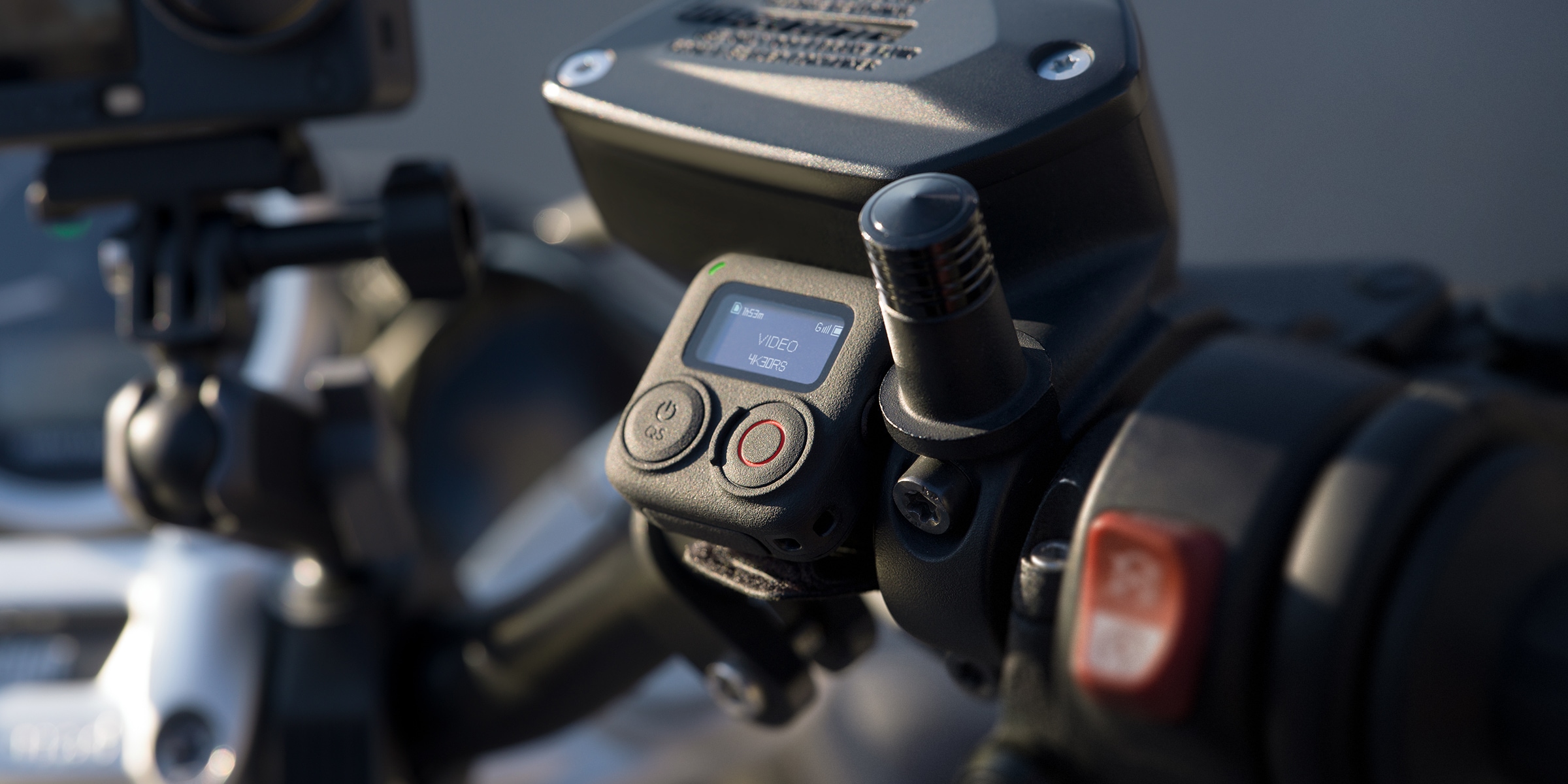 DJI Osmo Action camera mounted on handlebars showing a 4K30 recording mode on the rear screen