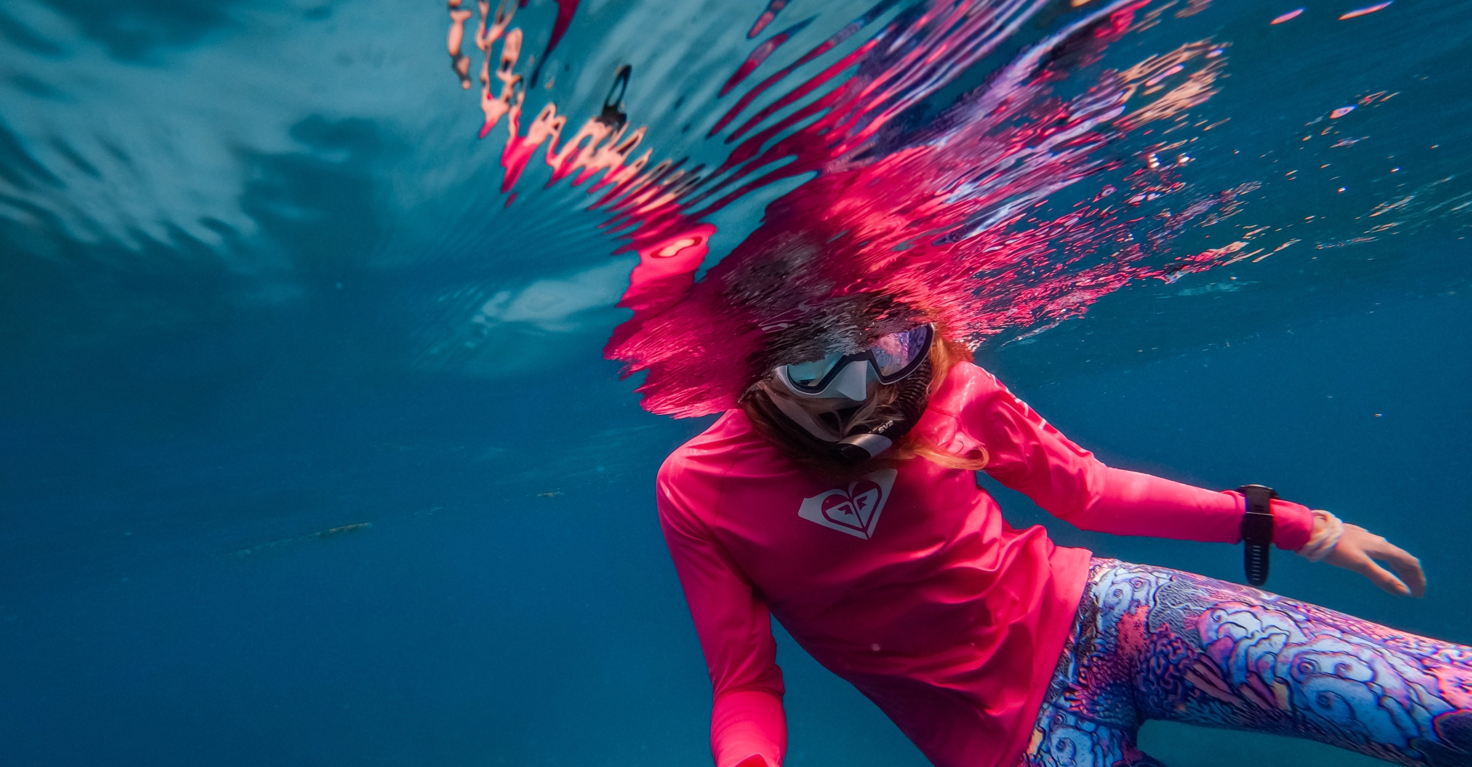 Underwater surfer in pink showing the 10-bit colour of the GoPro Hero 13 Black
