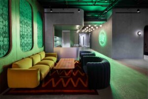Spotify lounge interior with the green Spotify logo glowing on a concrete wall