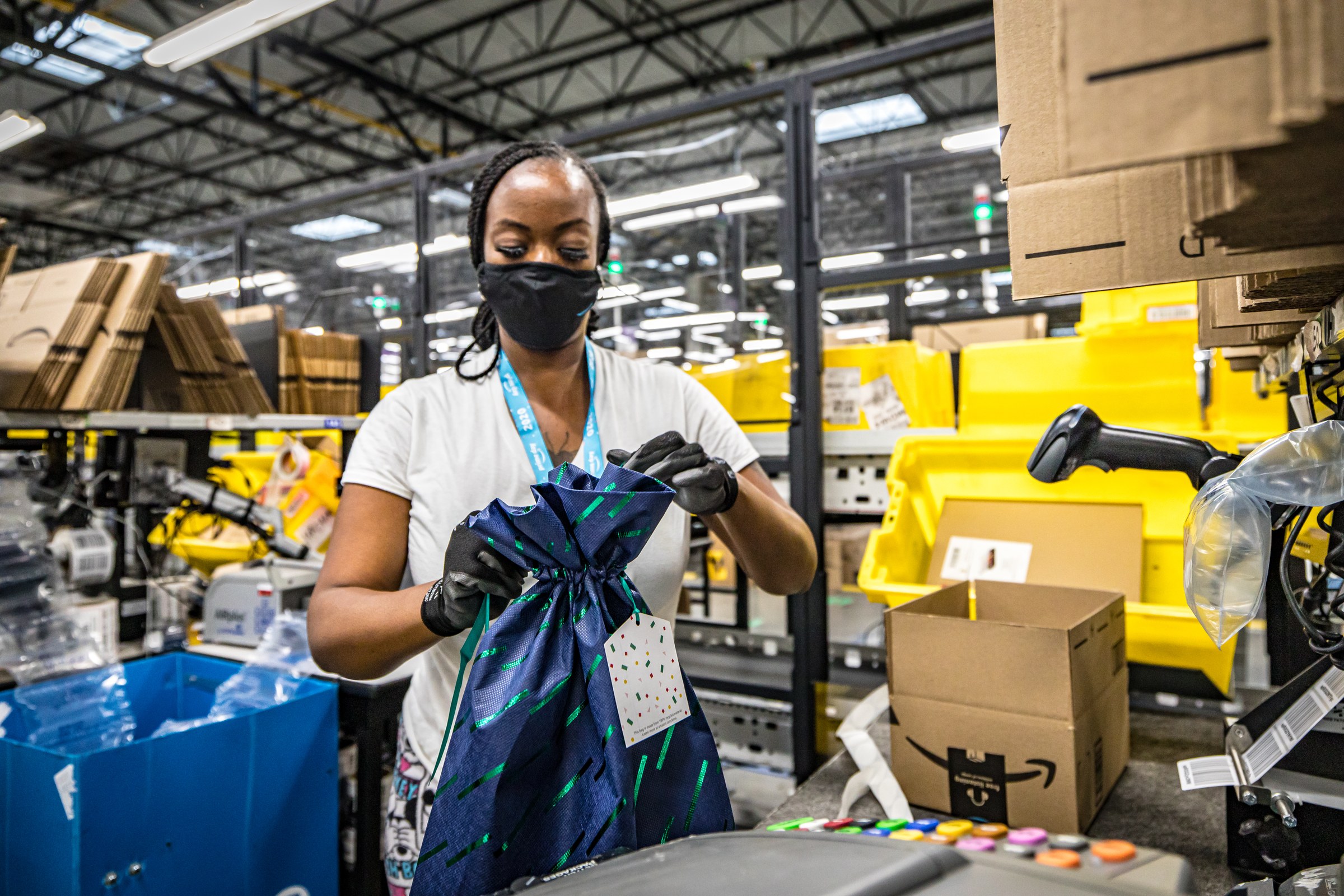 Amazon worker packing a parcel at a fulfilment station during a busy sales period