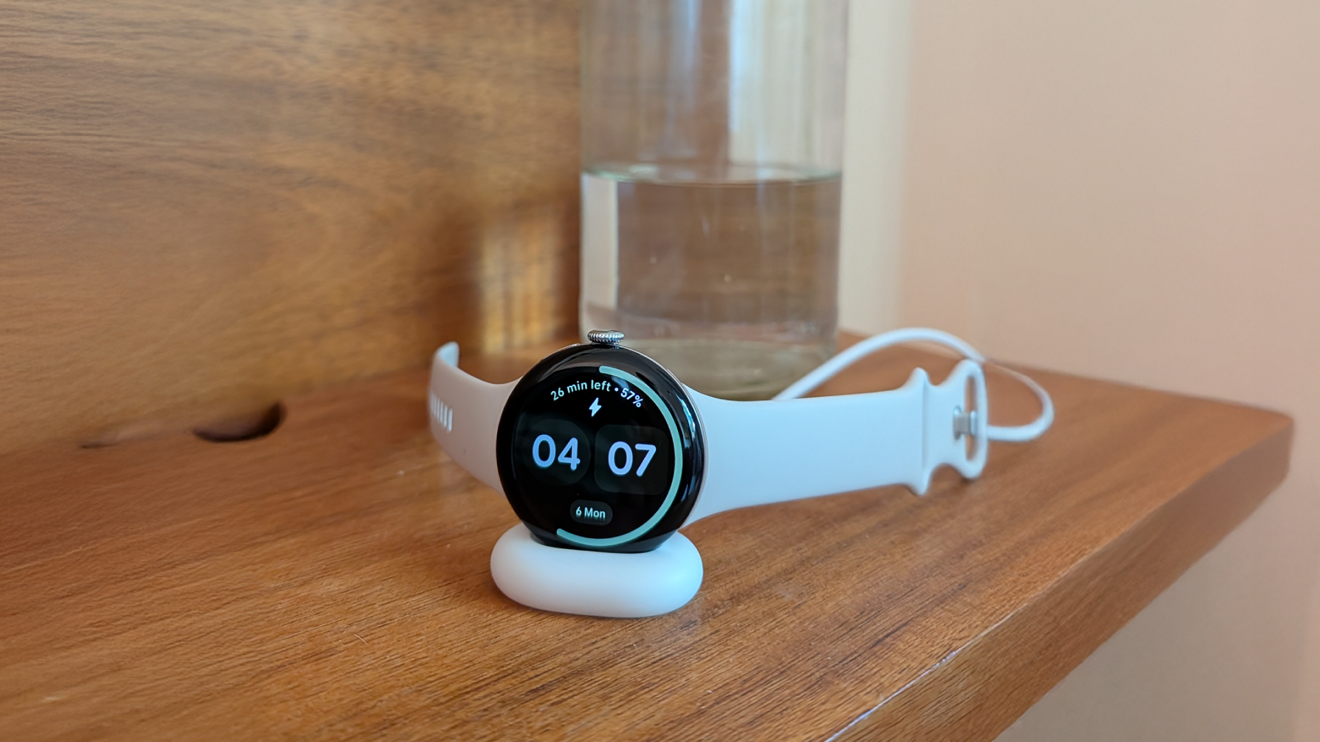 Google Pixel Watch 4 resting on its charging puck, the battery question behind any smartwatch upgrade
