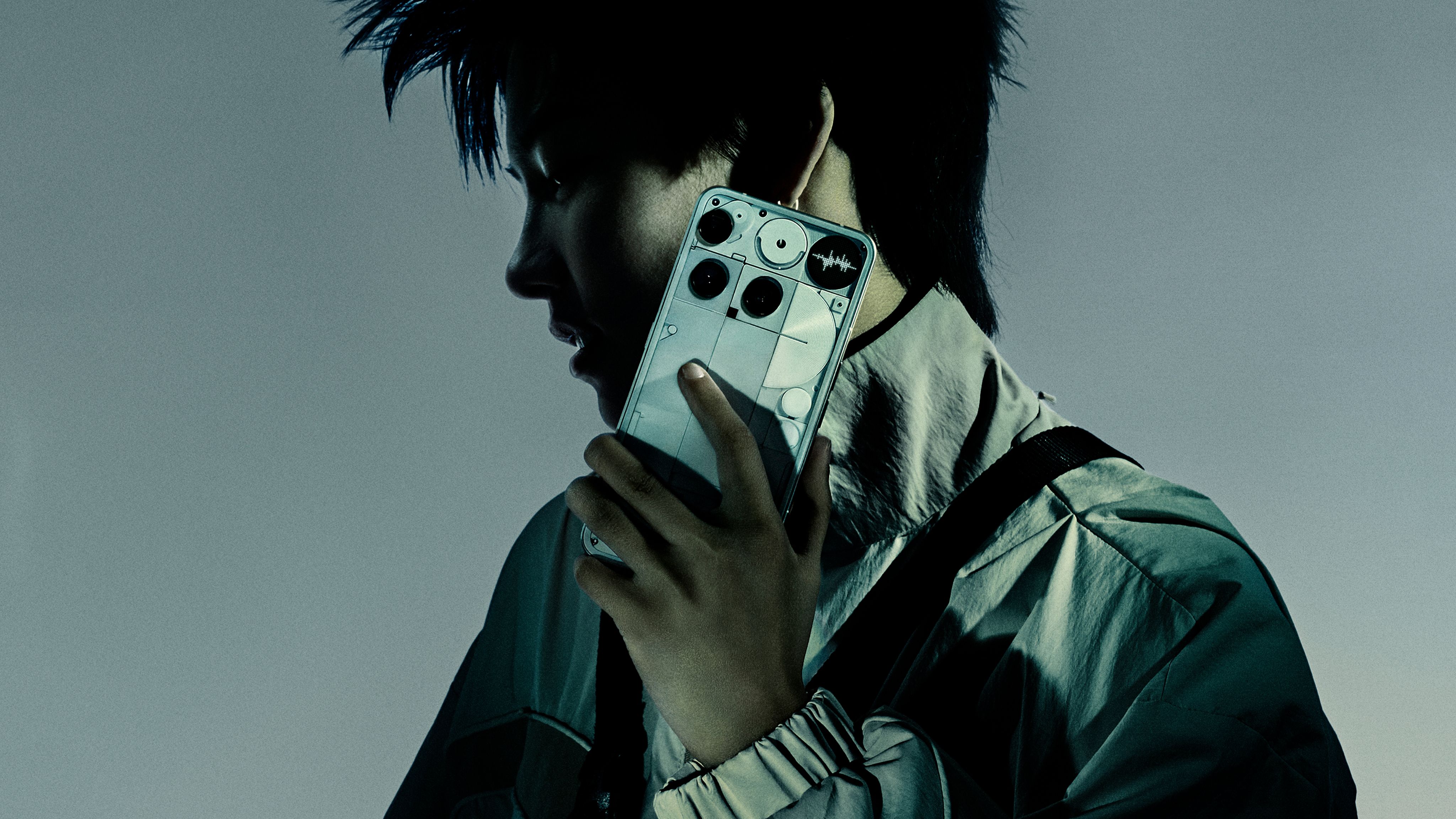 White Nothing Phone (3) held to the ear with the Glyph Matrix visible