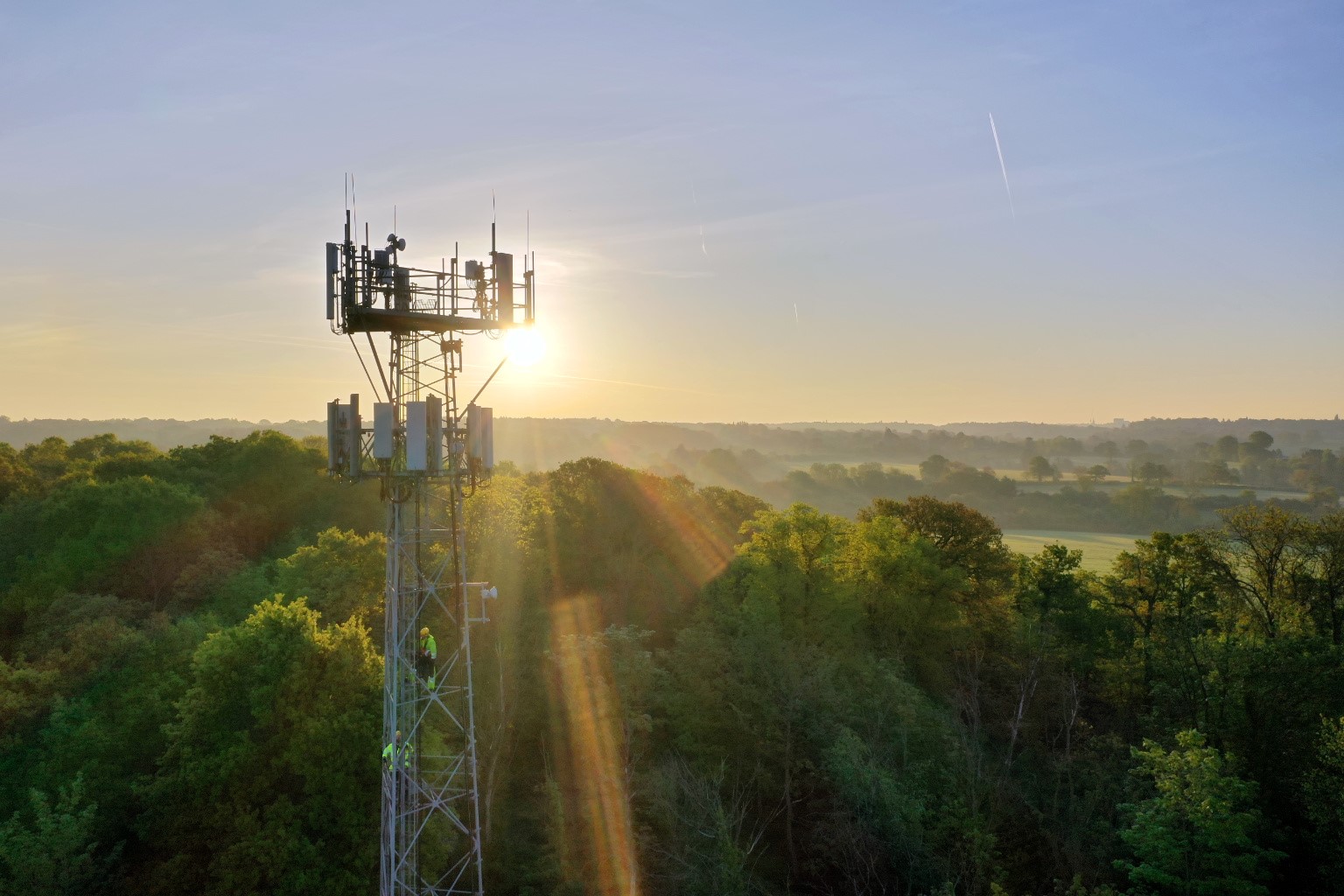 VodafoneThree mast at sunrise carrying 5G equipment across the UK countryside