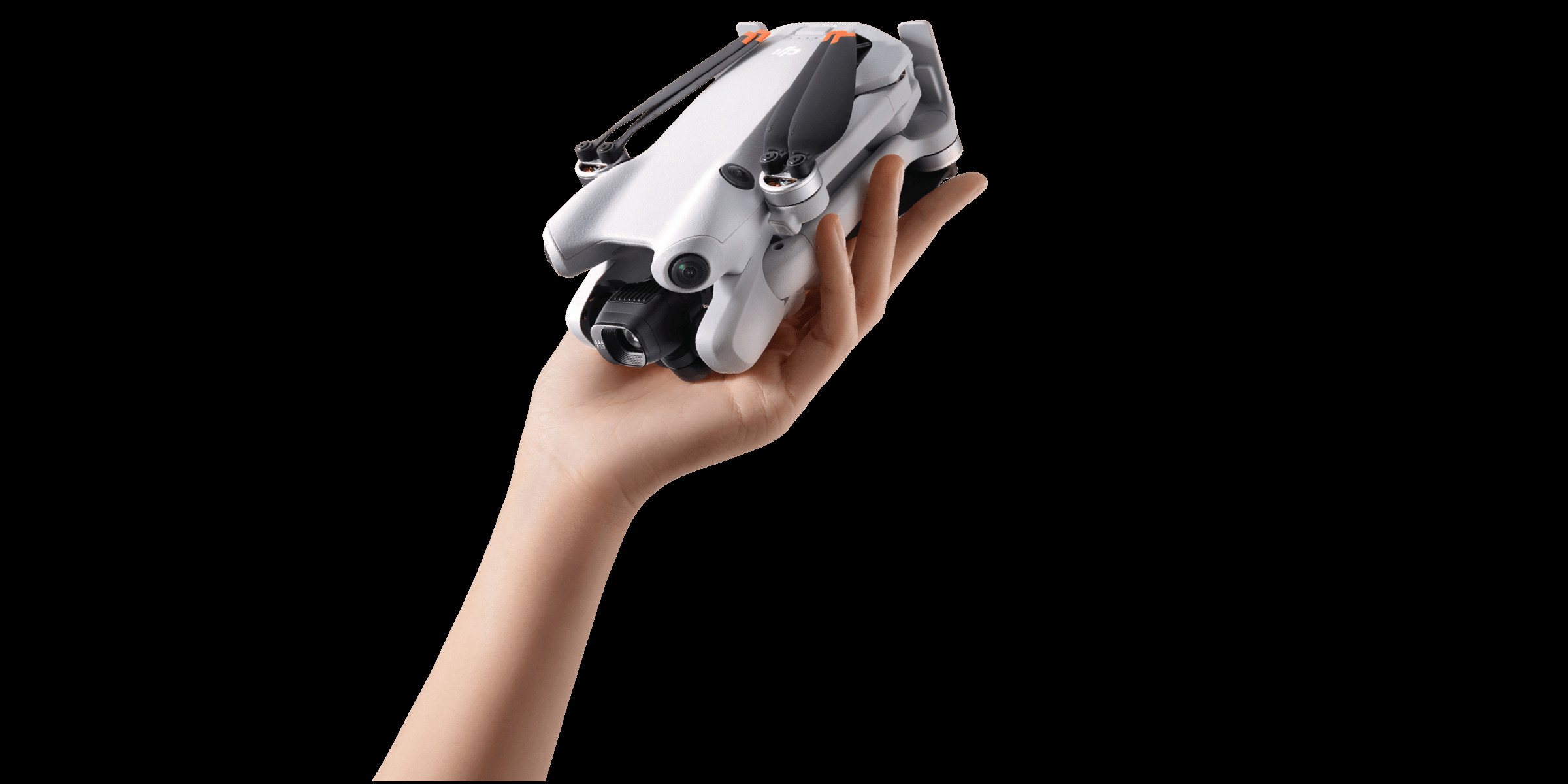 DJI Mini 4 Pro folded grey drone resting in an open palm against white
