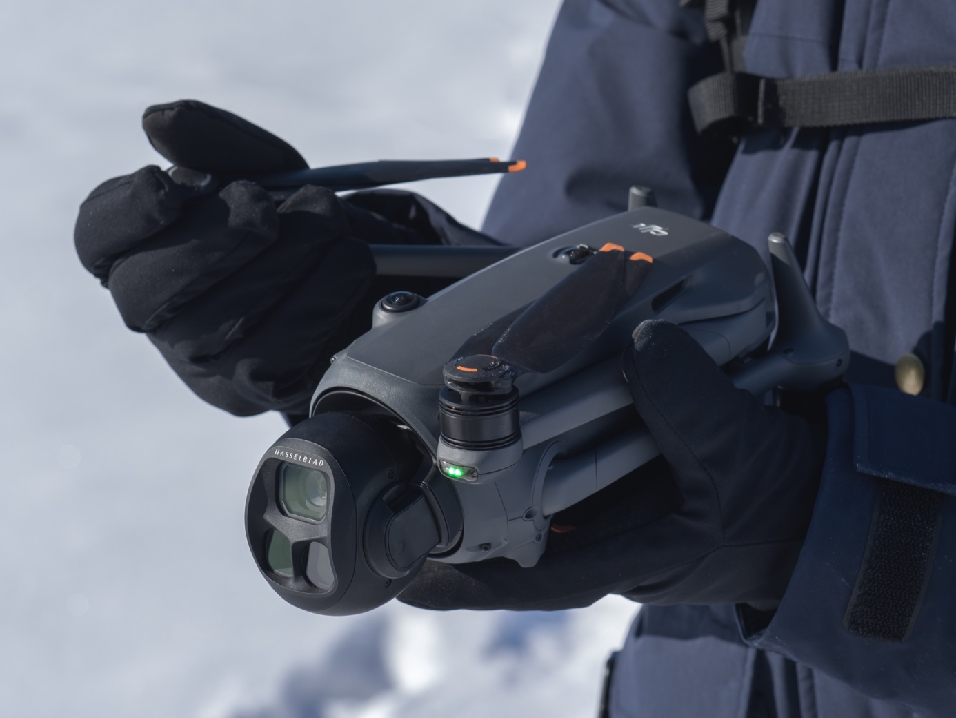 Close-up of the DJI Mavic 4 Pro triple-camera Hasselblad gimbal held in gloved hands