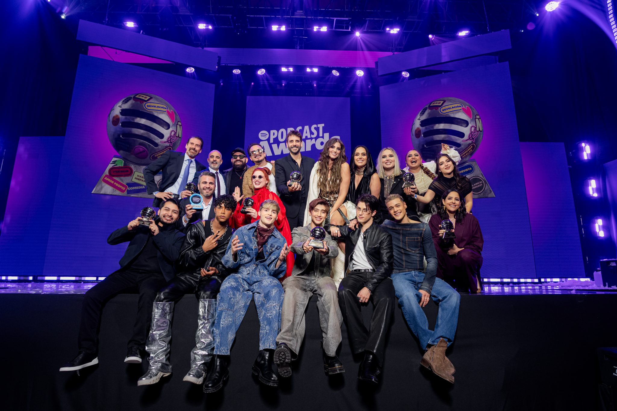 Spotify video podcasts UK: podcast creators holding trophies on stage at the Spotify Podcast Awards