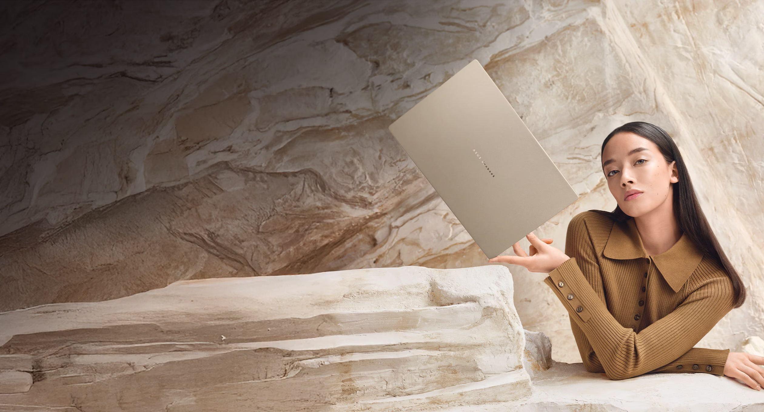 A person holds the slim ASUS Zenbook A16 Snapdragon X2 laptop with three fingers