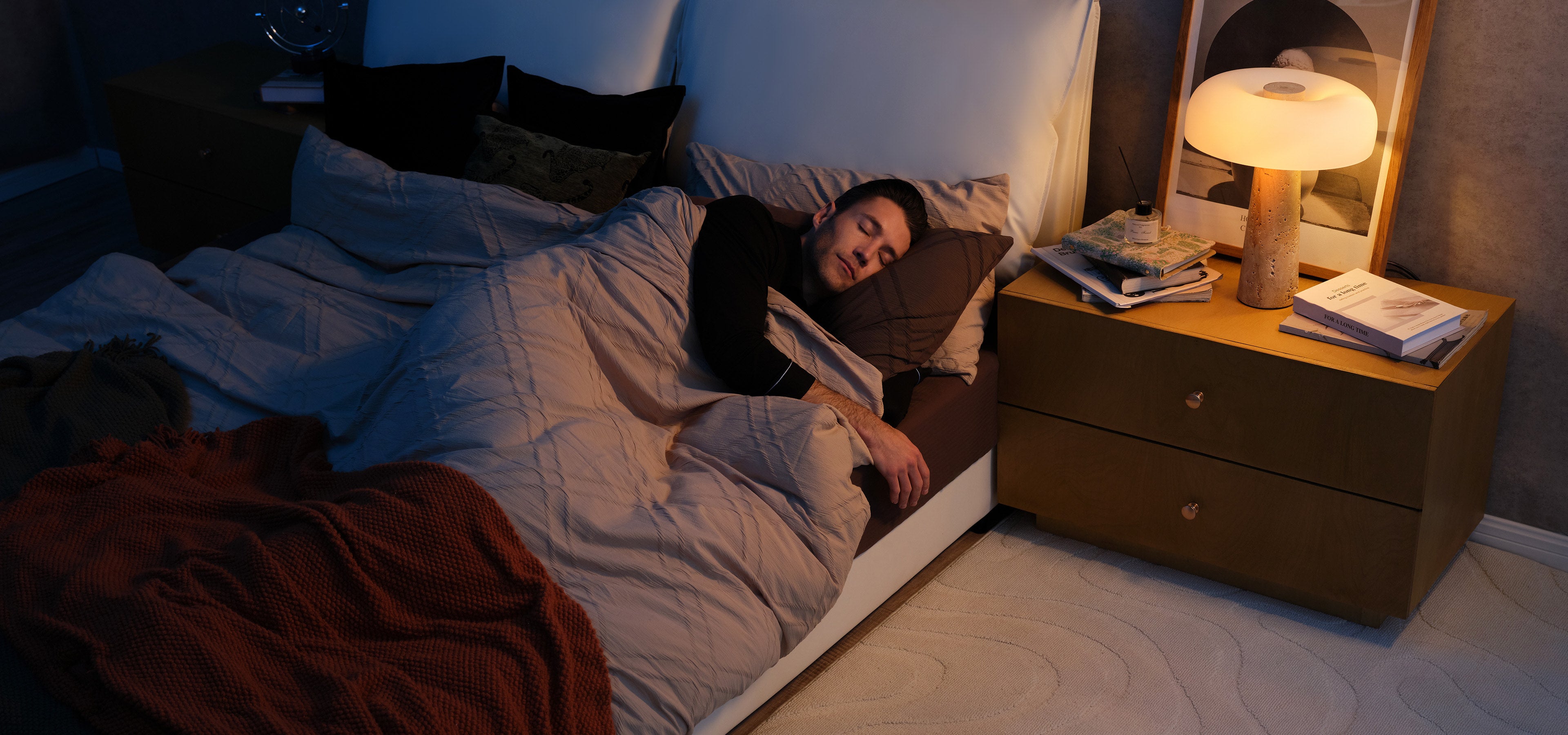 Roborock Saros 10 navigating a dimly lit bedroom while a person sleeps, illustrating quiet night cleaning