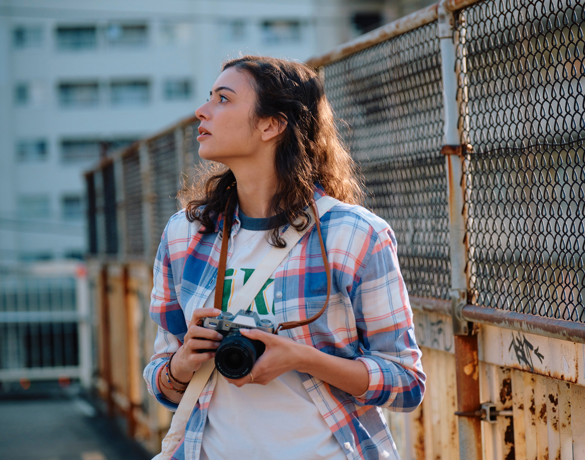 Street photographer carrying the Fujifilm X-T50 on a neck strap in golden evening light