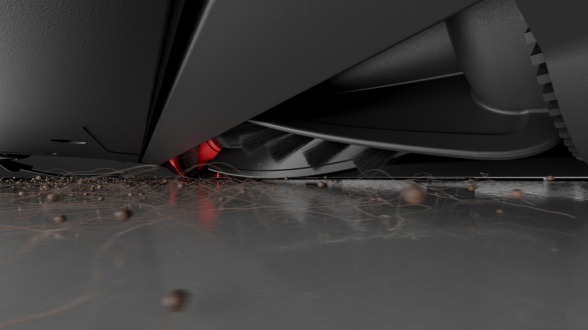 Close-up under the Roborock Saros 10 showing the anti-tangle brush sweeping hair and grit off a hard floor