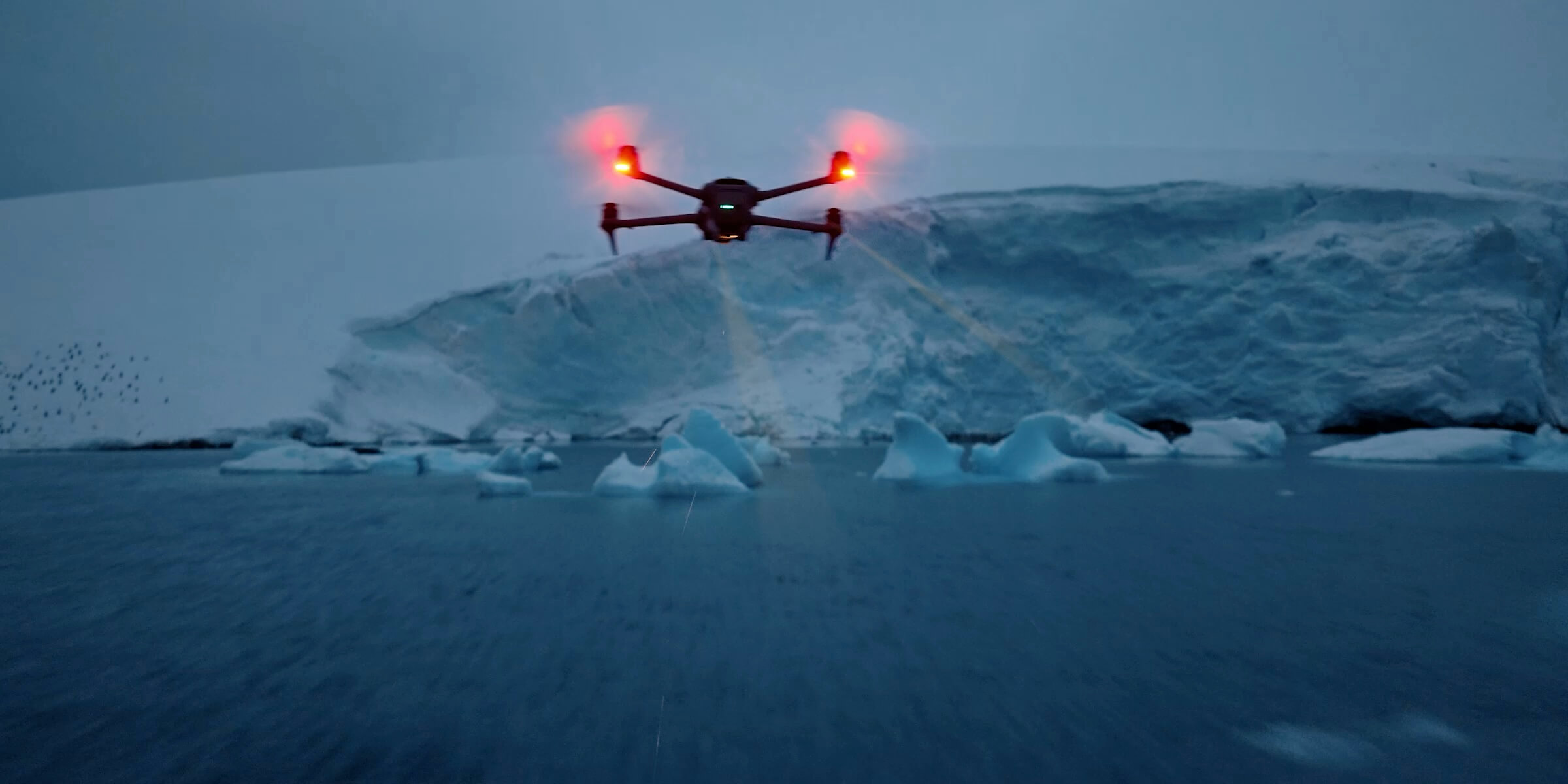 A person holding the DJI Mavic 4 Pro on a table, the rotating Infinity gimbal camera ball facing the lens