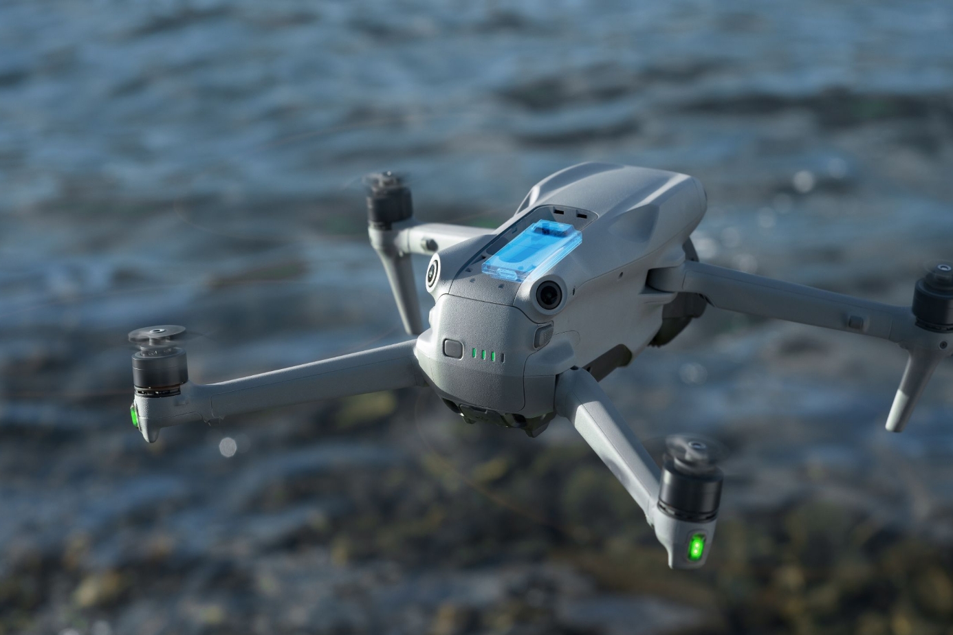DJI Air 3S dual-camera drone hovering in flight above water with the gimbal facing forward