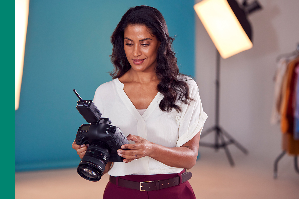 A self-employed photographer reviewing her camera, illustrating who Making Tax Digital for Income Tax affects