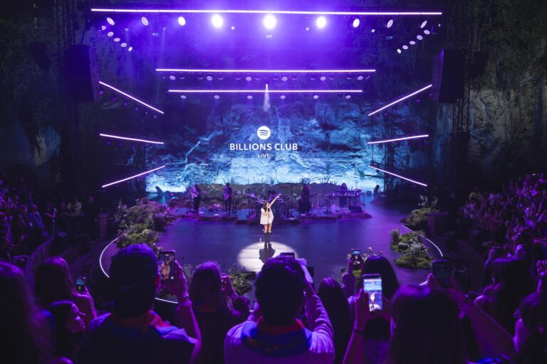 Olivia Rodrigo performing on a blue-lit stage at Spotify Billions Club Live in Barcelona